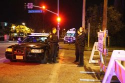 Barstow police officers stand guard as they investigate the crime scene on Dec. 2, 2015 in San Bernardino, California.