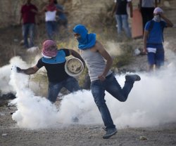 Palestinian youths amid tear gas