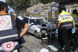 Police and emergency services respond to an attack in Jerusalem on October 13, 2015 after Palestinian rammed a vehicle into a bus stop then got out and started stabbing people.