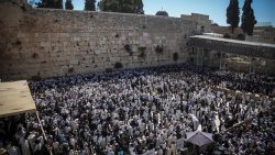 Jewish worshipers cover themselves with prayer shawls as they pray in front of the Western Wall in Jerusalem's Old City during the priestly blessing on Passover, a holiday which commemorates the Israelites' hasty departure from Egypt. April 6, 2015.