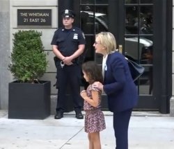 Hillary Clinton placing her hands on a girl's shoulders