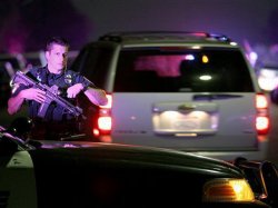 A San Diego Police officer helps to secure the scene near the corner of 39th Street and Boston Avenue in San Diego near where two San Diego Police officers were shot Thursday night, July 28, 2016.
