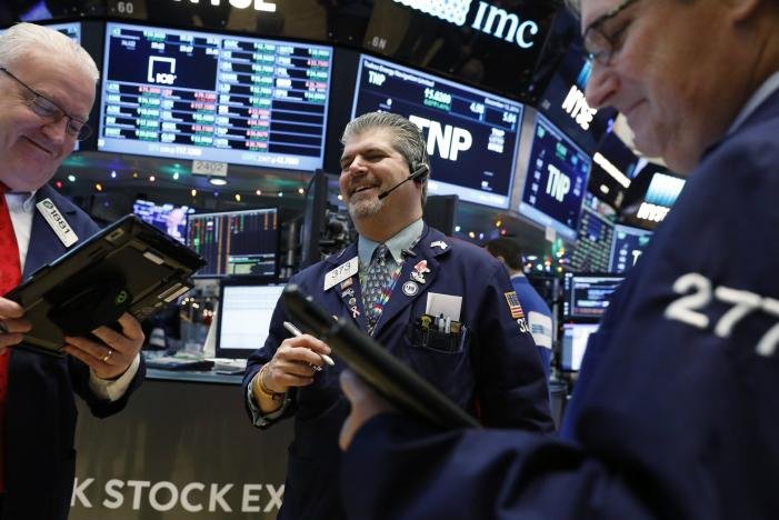 Traders laugh as they work on the floor of the New York Stock Exchange (NYSE) shortly after the opening bell in New York, NY, U.S. December 13, 2016. REUTERS/Lucas Jackson