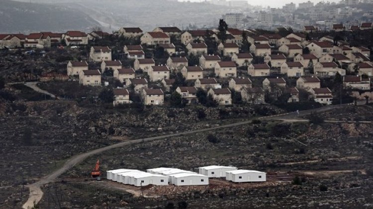 New prefabricated homes are seen under construction in the West Bank between the Israeli outpost of Amona and the settlement of Ofra (background), north of Ramallah, on January 31, 2017. (AFP/Thomas Coex)