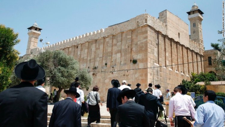 A picture taken on July 7, 2017 shows religious Jews and tourists walking towards the Cave of the Patriarchs, also known as the Ibrahimi Mosque.