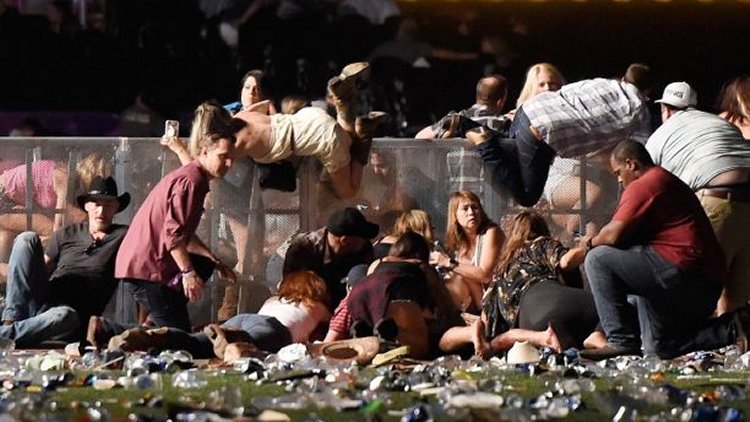 People scramble for shelter at the Route 91 Harvest country music festival after gun fire was heard on October 1, 2017 in Las Vegas, Nevada.  (Photo by David Becker/Getty Images)
