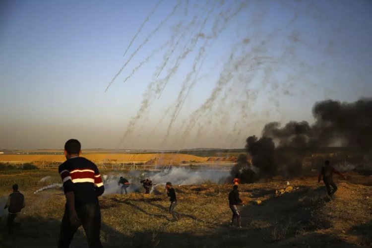 Palestinian protesters running from tear gas fired by Israeli forces along the Gaza-Israel border on Sunday. Credit Mohammed Abed/Agence France-Presse  Getty Images