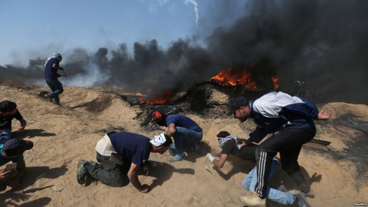 Palestinian demonstrators take cover from Israeli gunfire during a protest marking Jerusalem Day at the Israel-Gaza border in the southern Gaza Strip, June 8, 2018.
