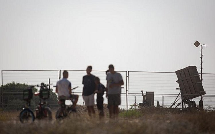 Israelis watch an Iron Dome missile defense battery stationed in southern Israel on July 14, 2018. (Hadas Parush/Flash90)