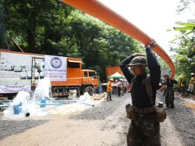Thai soldiers carry drainpipe July 4 toward the cave where a youth soccer team and its assistant coach have been trapped by water.