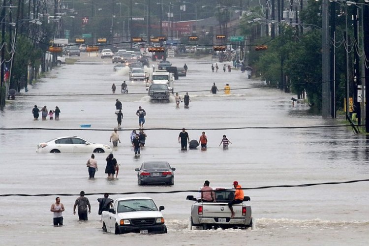 People waded through floodwaters in Houston on Sunday. Credit Thomas B. Shea/Agence France-Presse  Getty Images