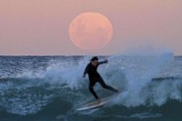 Surfer under total lunar eclipse in Australia